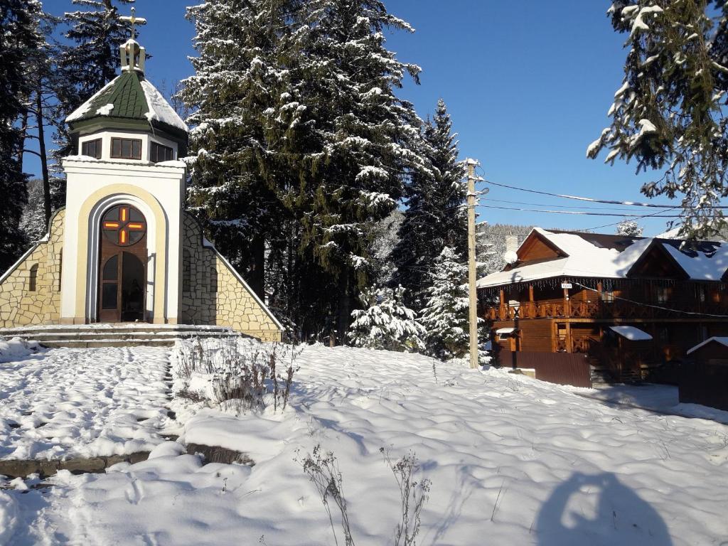 a church with a tower in the snow at Krym in Yaremche