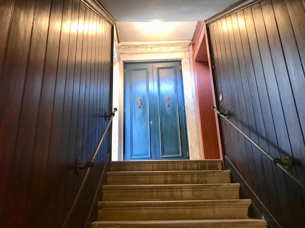 eine blaue Tür im Flur mit Treppe in der Unterkunft Ca' Bernarda in Venedig