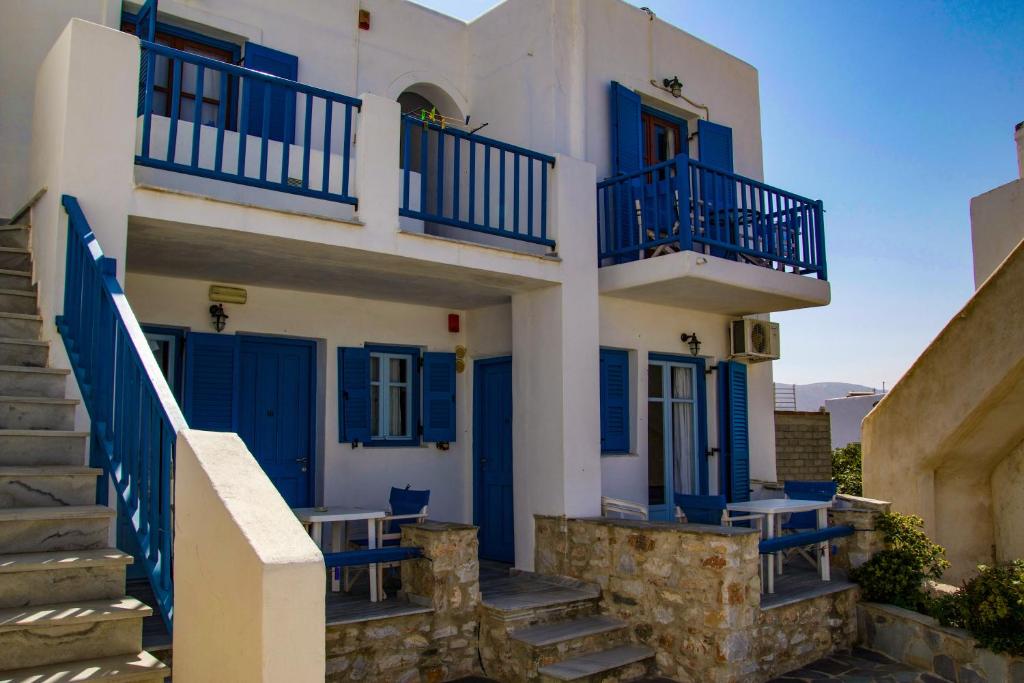 ein weißes Gebäude mit blauen Türen und Treppen in der Unterkunft Ioanna Rooms in Naoussa
