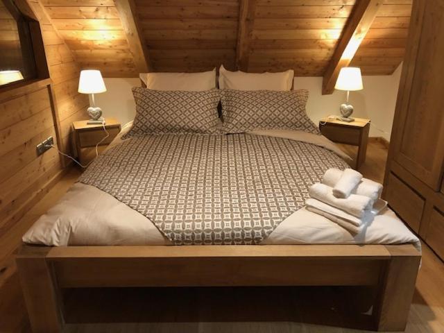 1 dormitorio con 1 cama grande y 2 lámparas en Chalet La Grange, en Auron