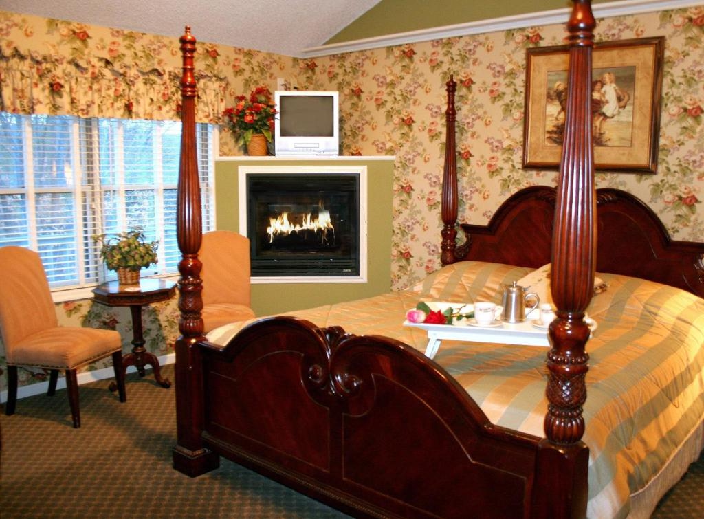 1 dormitorio con cama con dosel y chimenea en Afton House Inn en Afton