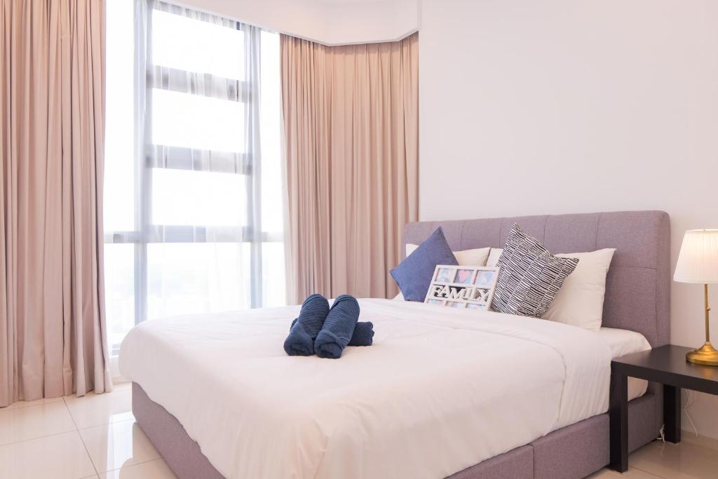 um quarto com uma cama grande com dois bichos de peluche em The Robertson Bukit Bintang by Wowhome em Kuala Lumpur