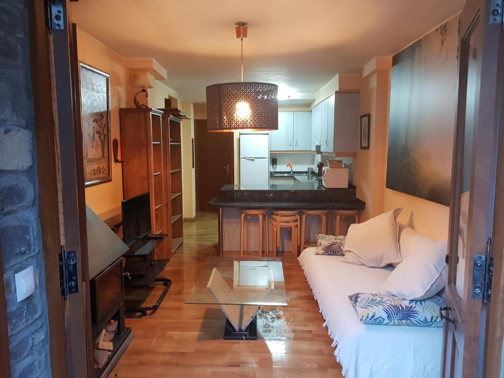 a living room with a white couch and a table at Apartamentos Nilsson, Casa Botigue, centro de Plan in Plan