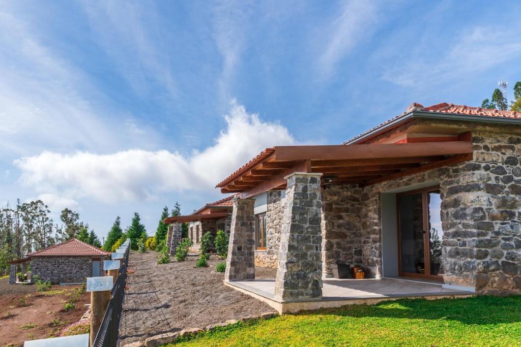 a stone house with a pathway leading up to it at Rochão Village by Rent2U, Lda in Calheta