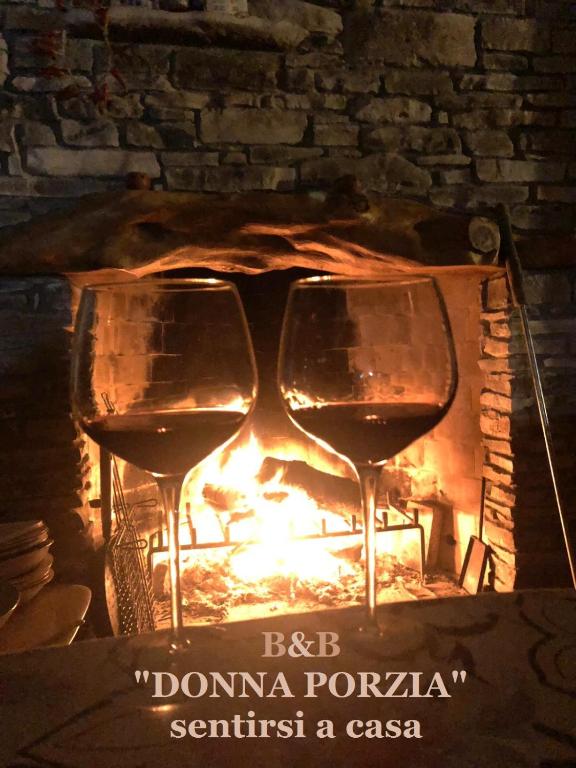 two glasses of wine sitting in front of a fire at B&B DONNA PORZIA in Trani