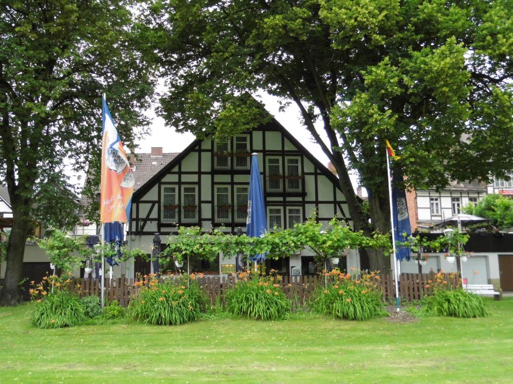 ボーデンヴェルダーにあるHotel Weserstubenの旗の前の黒い家