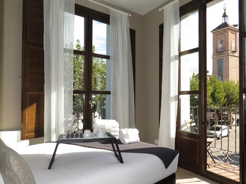 アルカラ・デ・エナレスにあるLa Casa Tahona Plaza de Cervantesのベッドルーム1室(ベッド1台、大きな窓付)