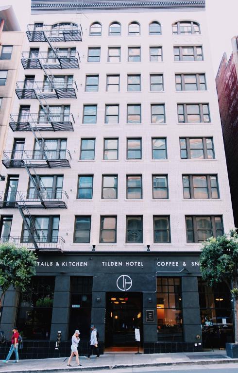 a large white building with people walking in front of it at Tilden Hotel Union Square in San Francisco