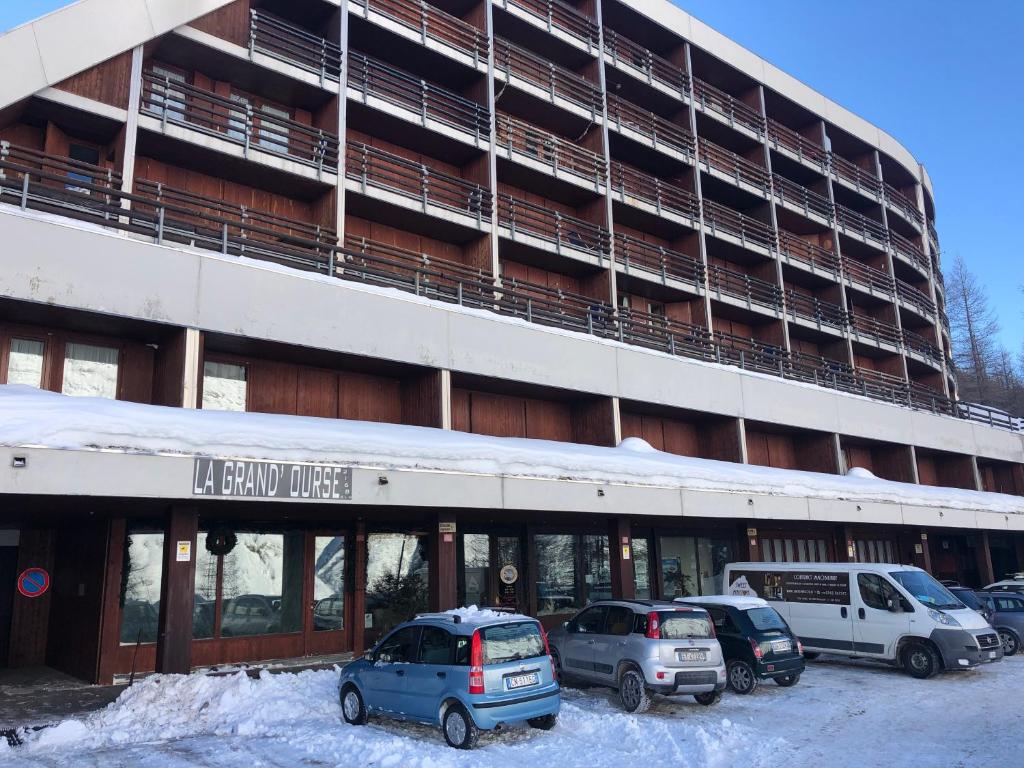 a parking lot with cars parked in front of a building at Monolocale Cielo Alto in Breuil-Cervinia
