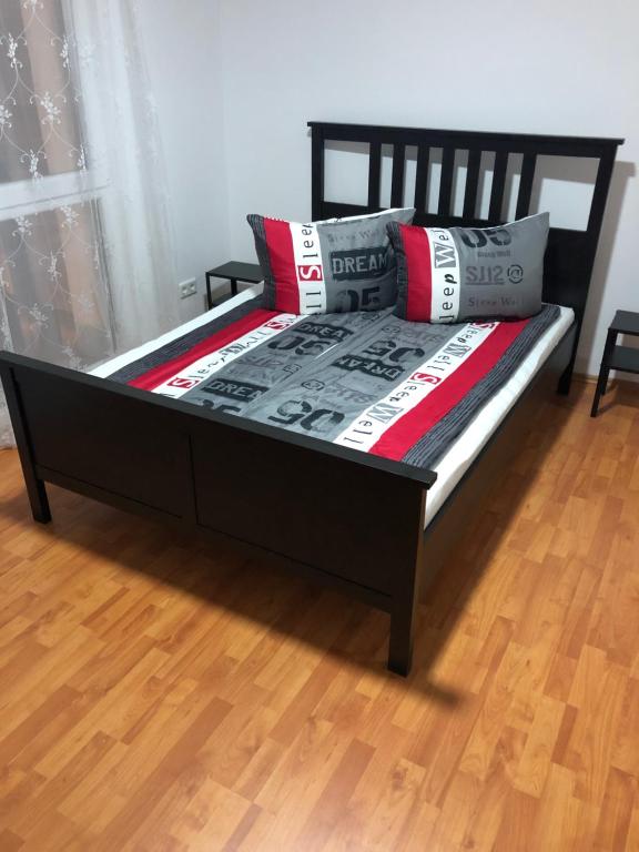 a black bed with pillows on top of a wooden floor at Apartment 4 Rent in Bochum