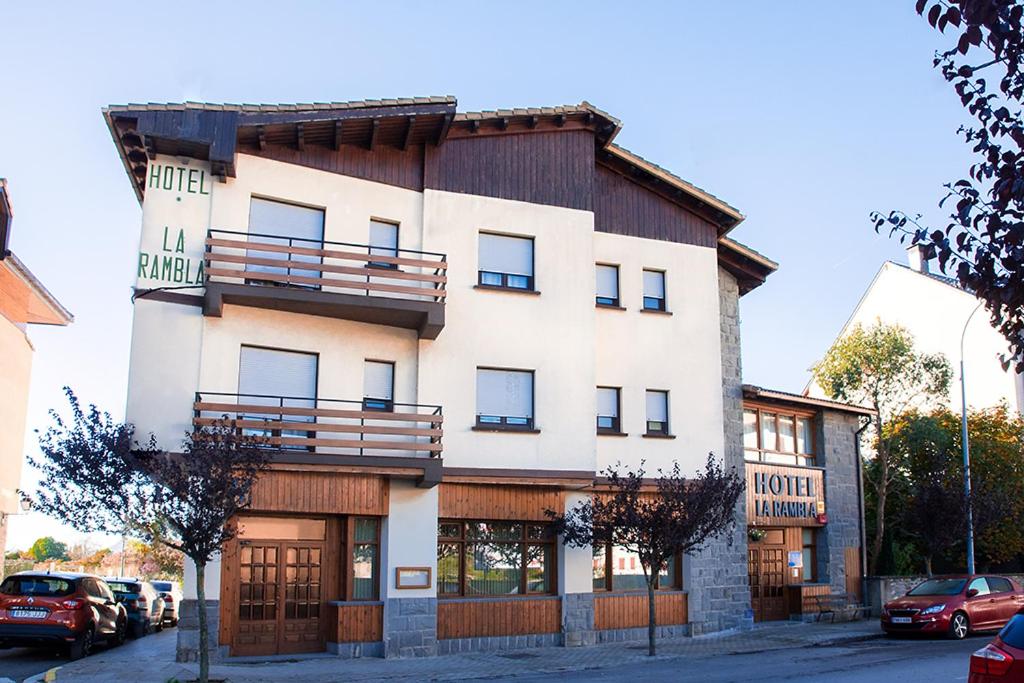 Un grand bâtiment blanc avec balcon est disponible. dans l'établissement Hotel La Rambla, à Biescas