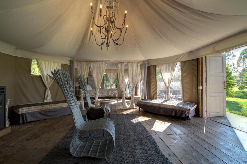 a room with a tent with a couch and a chandelier at Glamping Canonici di San Marco in Mirano