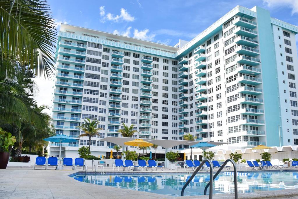 a large building with a pool in front of it at Seacoast Suites on Miami Beach in Miami Beach