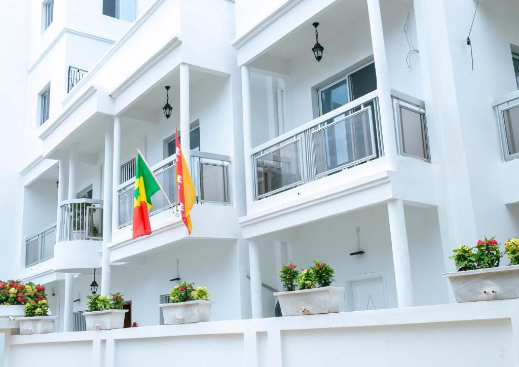 un edificio de apartamentos blanco con dos banderas en la ventana en J PAD, en Dakar