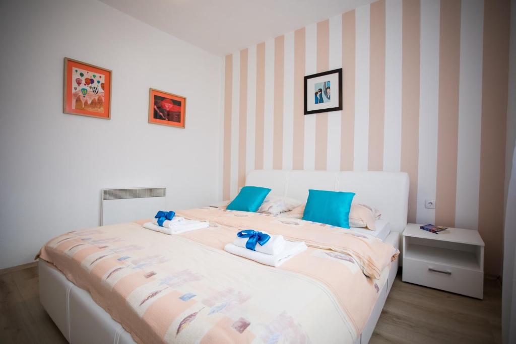 ein Schlafzimmer mit einem großen weißen Bett mit blauen Kissen in der Unterkunft Guest house PiN in Laktaši