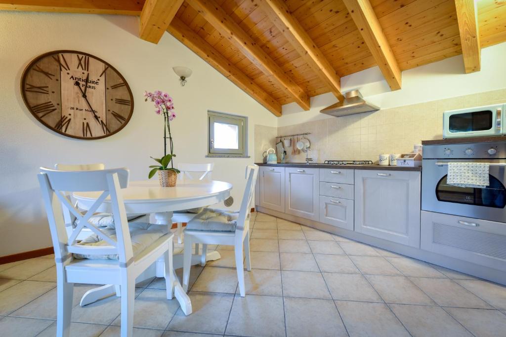 a kitchen with a table and a clock on the wall at Villa dei Venti - Comfort Holiday in Bergamo