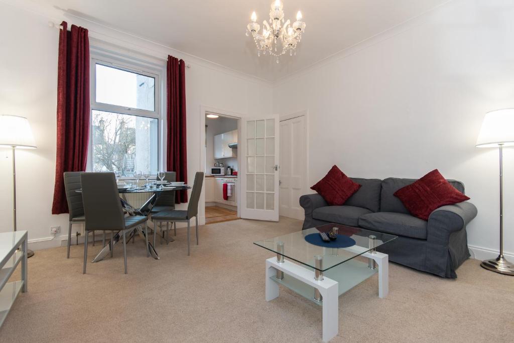 uma sala de estar com um sofá e uma mesa em Glebe Street Apartment em Fife