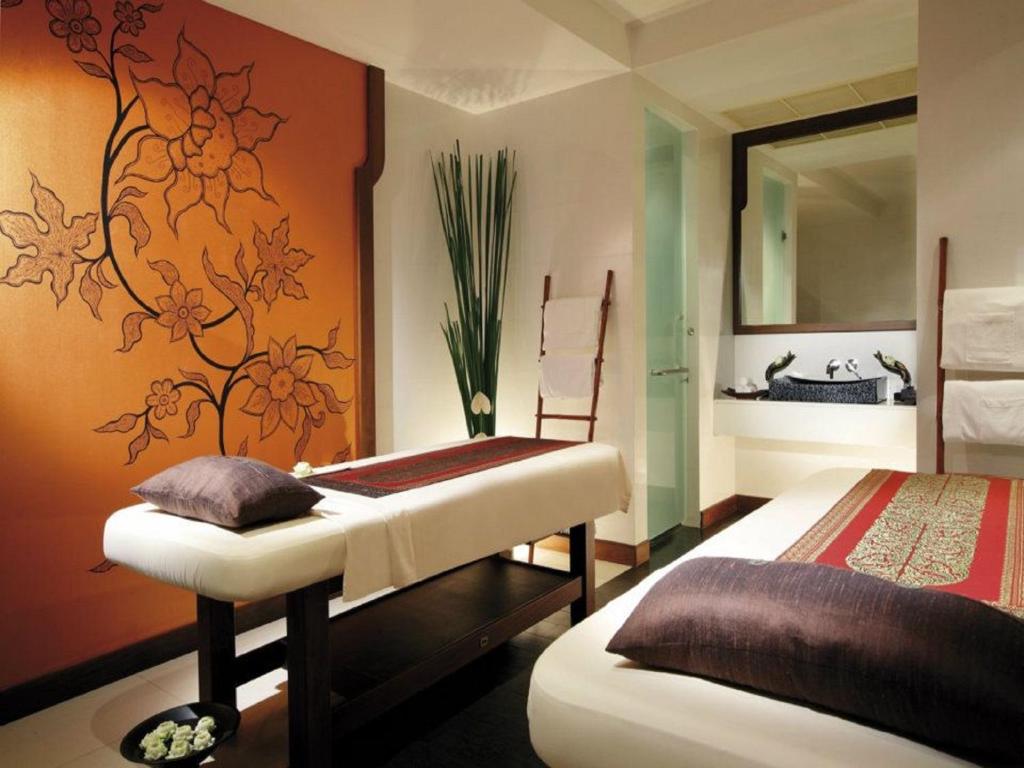 a bedroom with two beds and a mirror at Mövenpick Resort Bangtao Beach Phuket in Bang Tao Beach