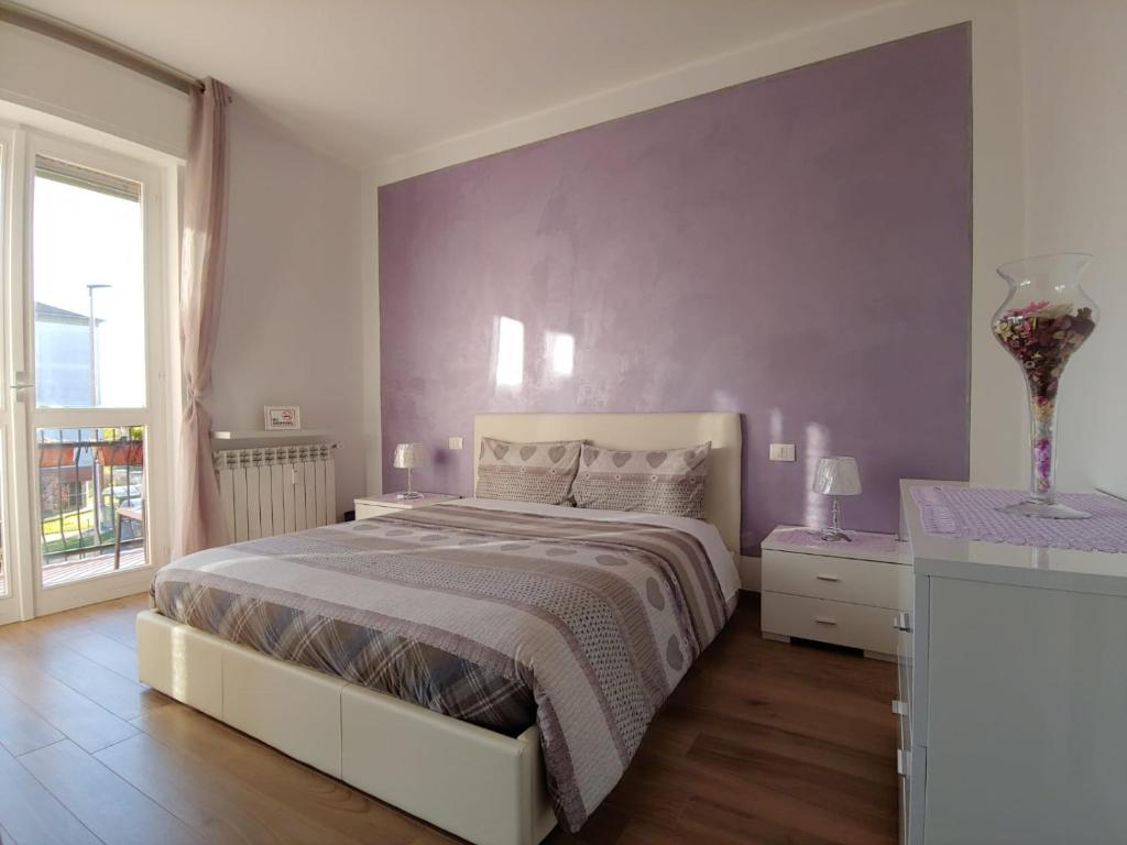 ベルガモにあるLa casa di Luciaの紫の壁のベッドルーム1室(ベッド1台付)