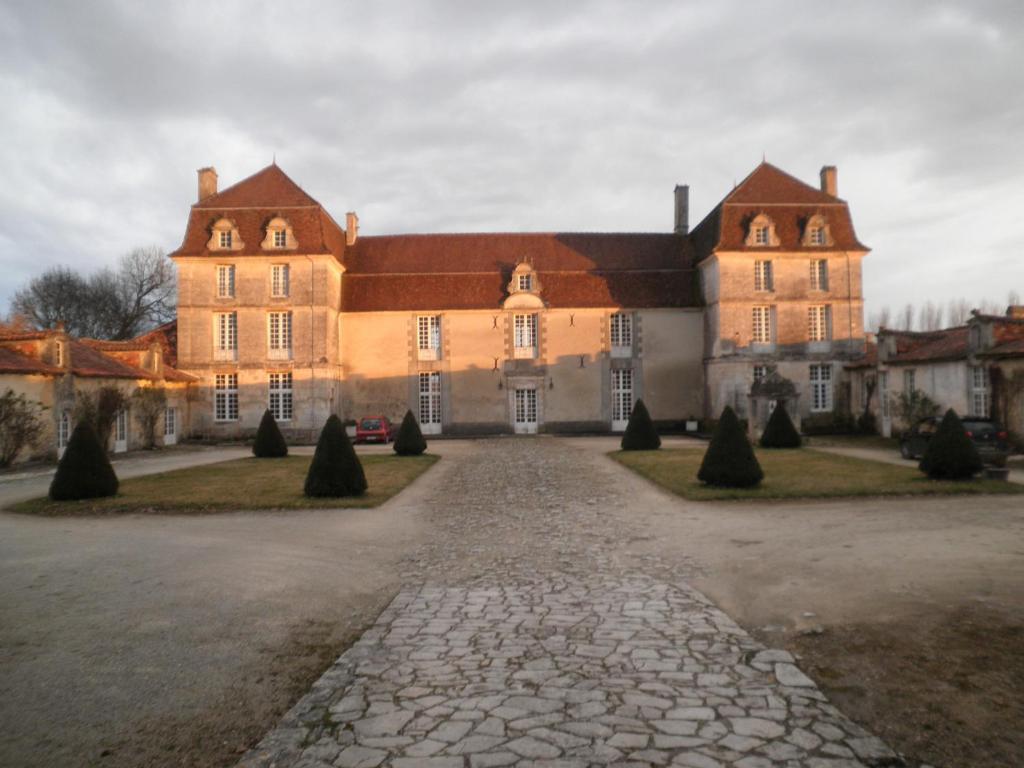 a large house with a stone driveway in front of it at Chambres d'Hôtes et Gîtes du Château de Clauzuroux in Champagne-et-Fontaine