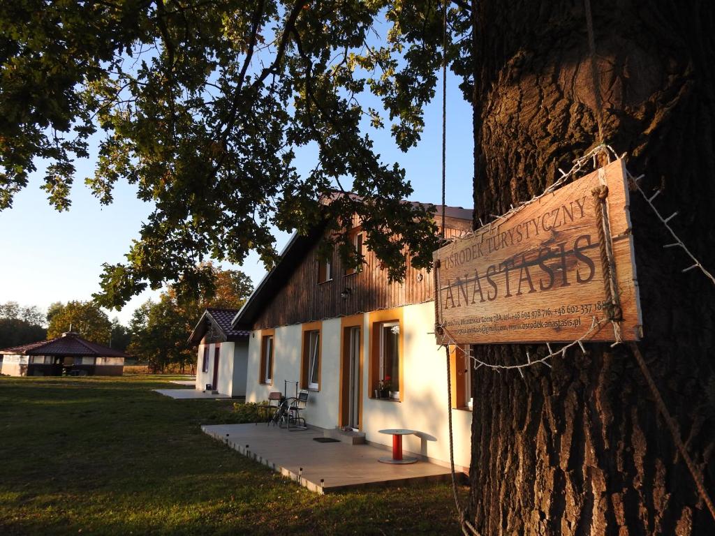 um sinal numa árvore em frente a um edifício em Anastasis em Mirostowice Górne