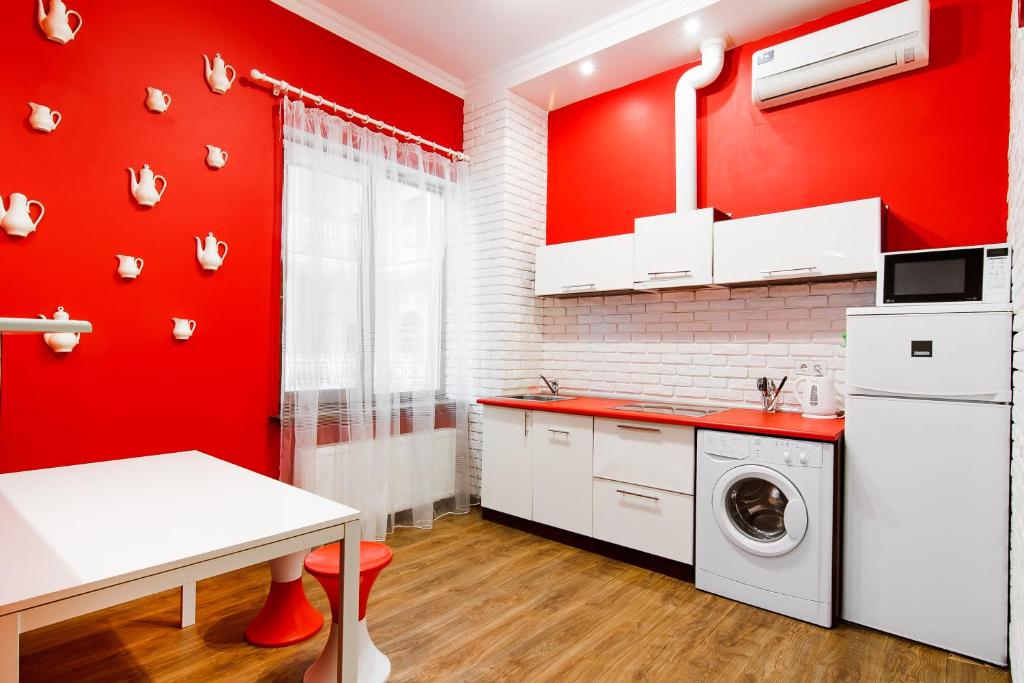 a kitchen with red walls and a washing machine at Modern Apartment in the city center in a new building in Odesa