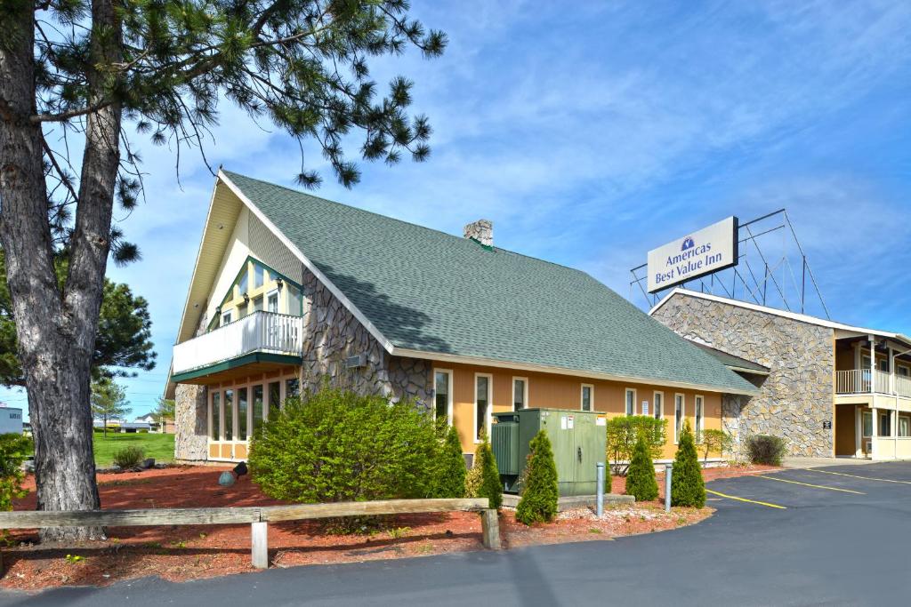 un edificio con una señal delante de él en Americas Best Value Inn Plattsburgh, en Plattsburgh