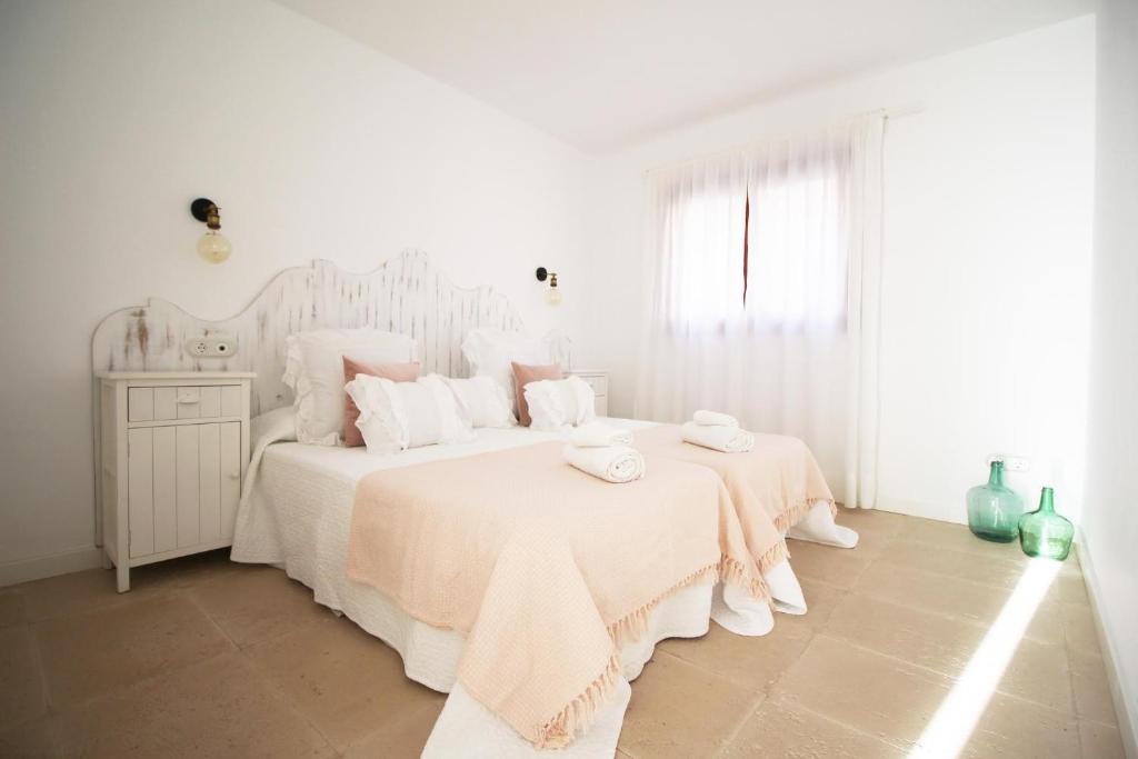 ein weißes Schlafzimmer mit einem großen Bett mit weißer Bettwäsche in der Unterkunft Sa Tanqueta in Ses Salines
