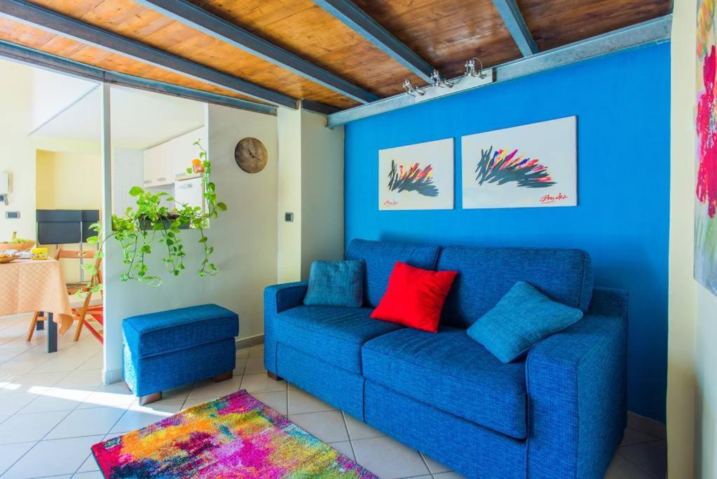 a blue living room with a blue couch and red pillows at La Stanzetta in Naples