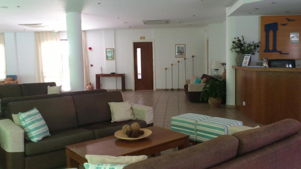 a living room with couches and a coffee table at Hylatio Tourist Village in Pissouri