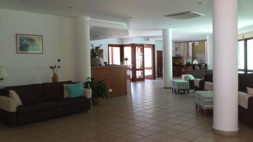 a living room with couches and chairs in a building at Hylatio Tourist Village in Pissouri