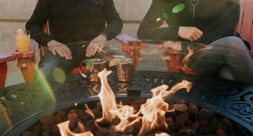 two men are sitting around a fire pit at Adara Hotel in Whistler