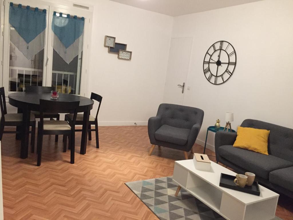 a living room with a couch and a table at Appartement Le Grand Parc in Châteauroux