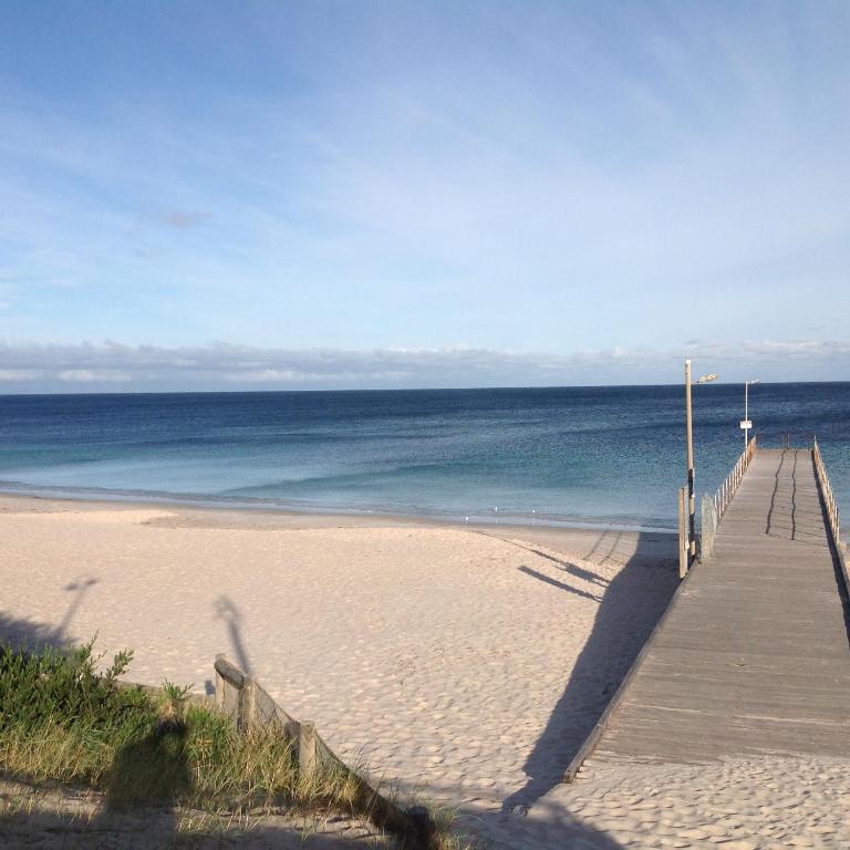 a wooden boardwalk leading to a beach with the ocean at Jetty Rd Granny Flat in Normanville