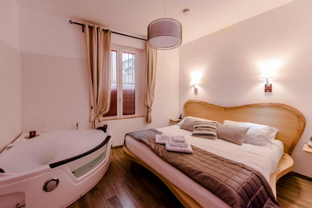 a bedroom with a tub and a bed and a sink at Flatinrome Trastevere Deluxe Rooms - Green Patio in Rome