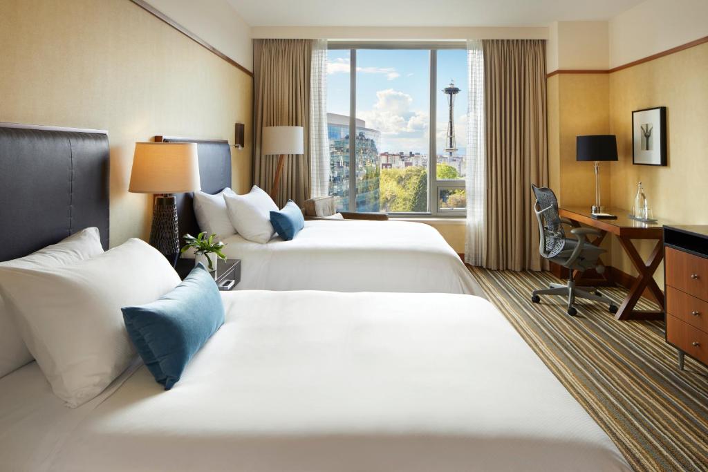 a hotel room with two beds and a television at Pan Pacific Seattle in Seattle