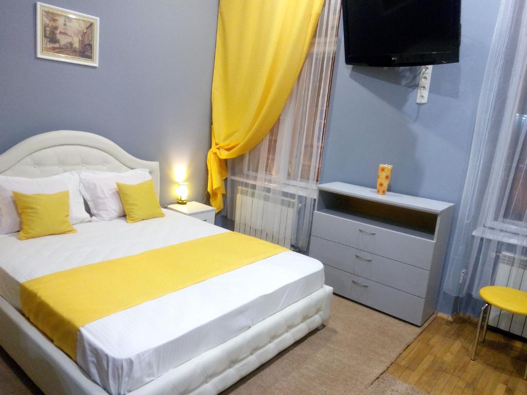 een slaapkamer met een bed en een televisie. bij Near Rynok Square in Lviv
