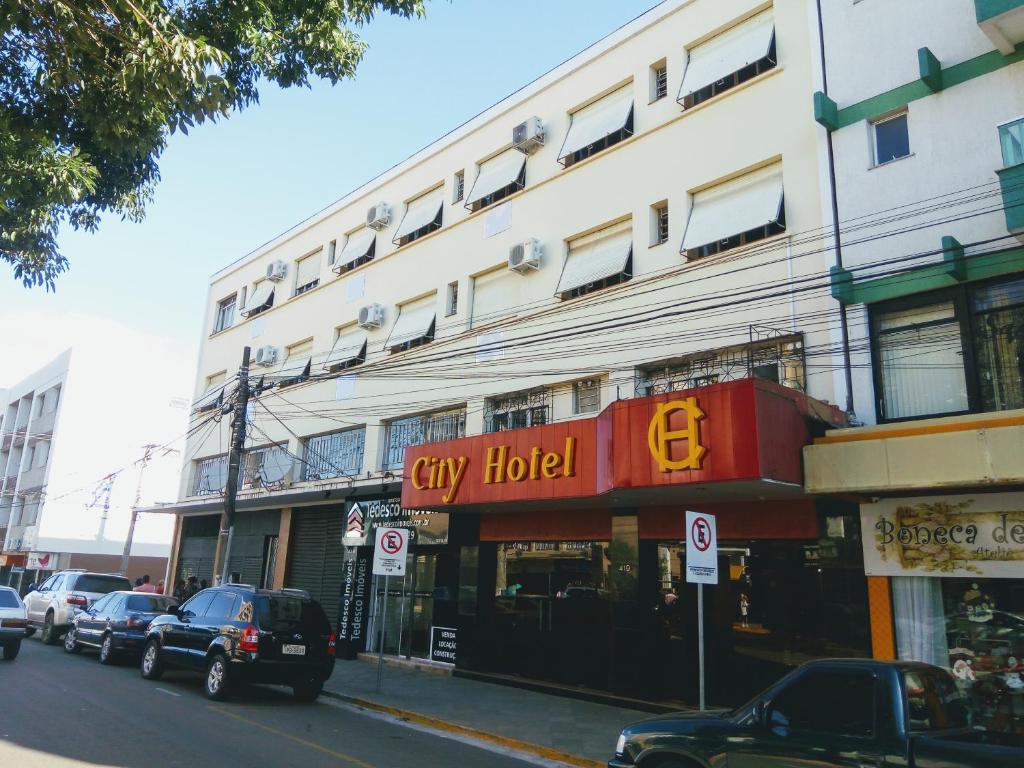 a large white building with a city hotel sign on it at City Hotel PF in Passo Fundo