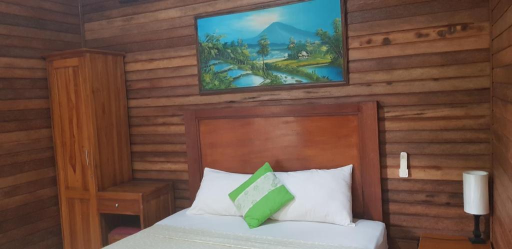 una camera da letto con un letto e una TV a parete di Surya Home Stay a Nusa Lembongan