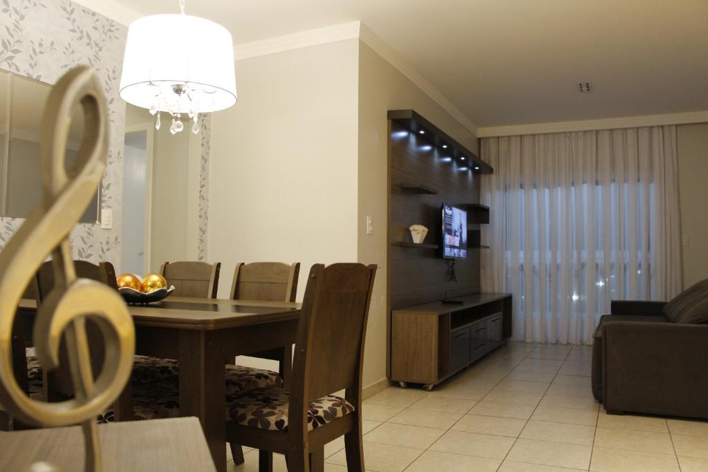 a dining room and living room with a table and chairs at 3qtos Quadra do Mar Lindo! in Guarapari