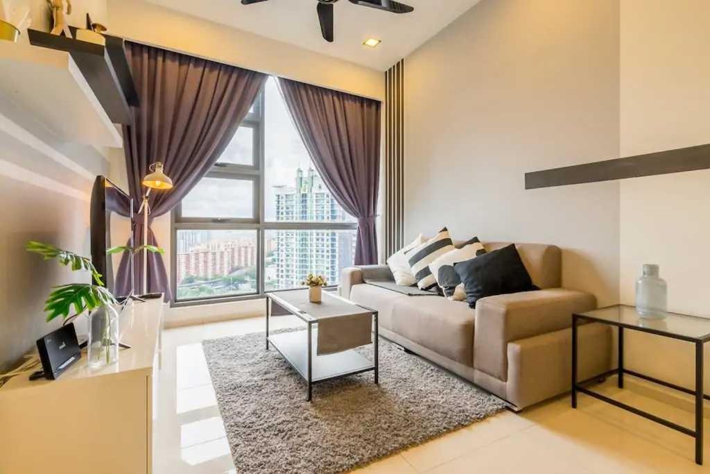 a living room with a couch and a large window at The Robertson Residences in Kuala Lumpur