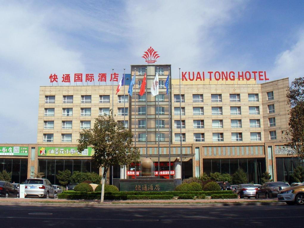 a building with a kuhnee hotel on top of it at Qingdao KuaiTong International Hotel in Qingdao