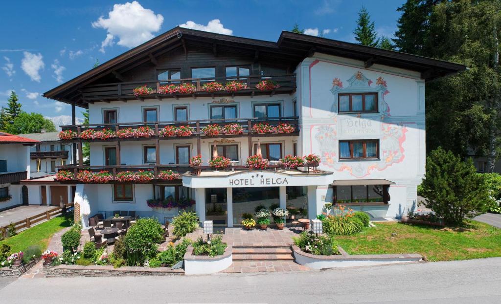een groot wit gebouw met bloemen ervoor bij Hotel Helga in Seefeld in Tirol