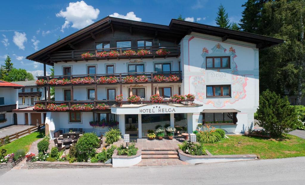 un grande edificio bianco con dei fiori di fronte di Hotel Helga a Seefeld in Tirol