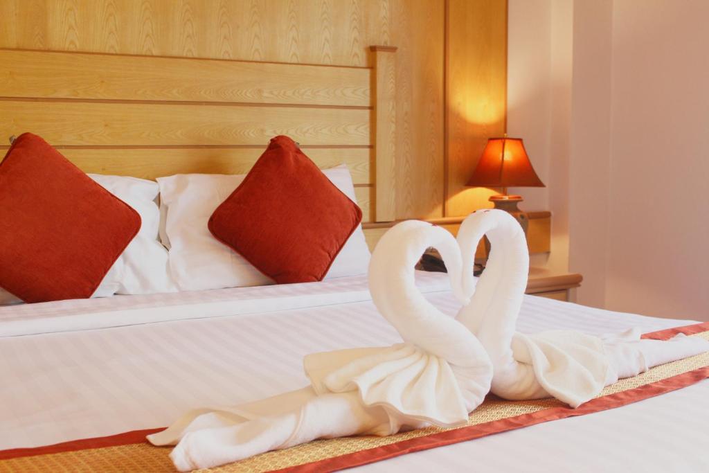 two white swans sitting on top of a bed at Baan Boa Resort in Patong Beach