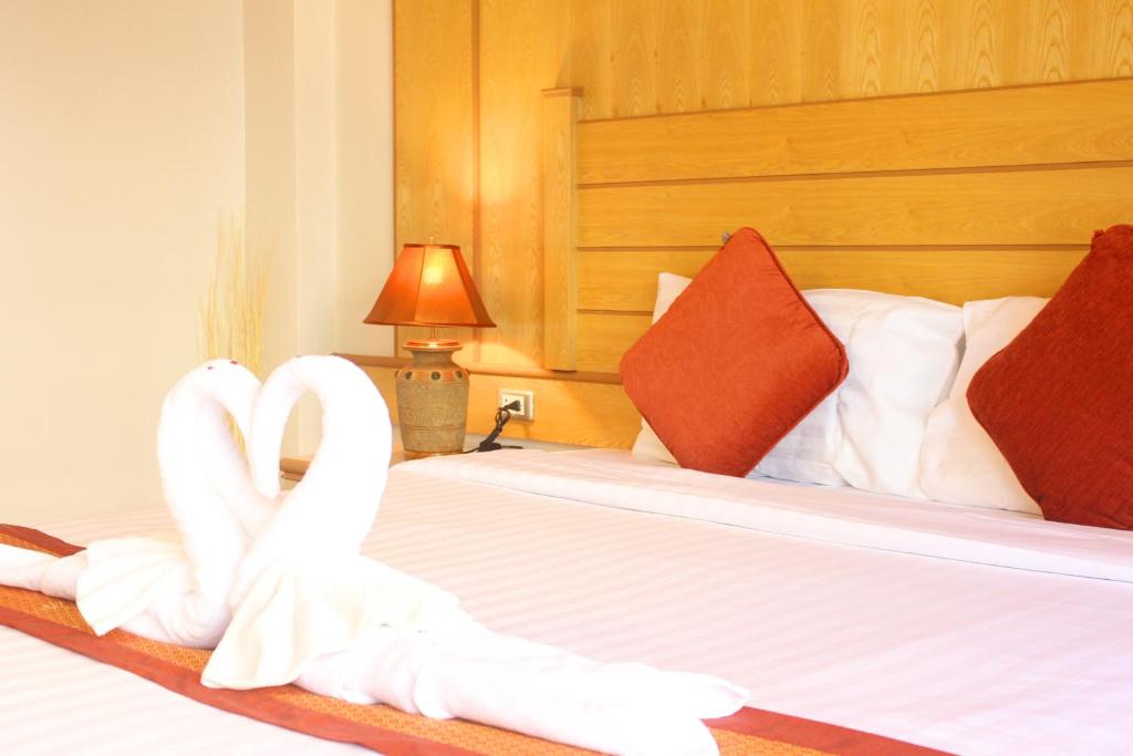 two swans towels sitting on top of a bed at Baan Boa Resort in Patong Beach