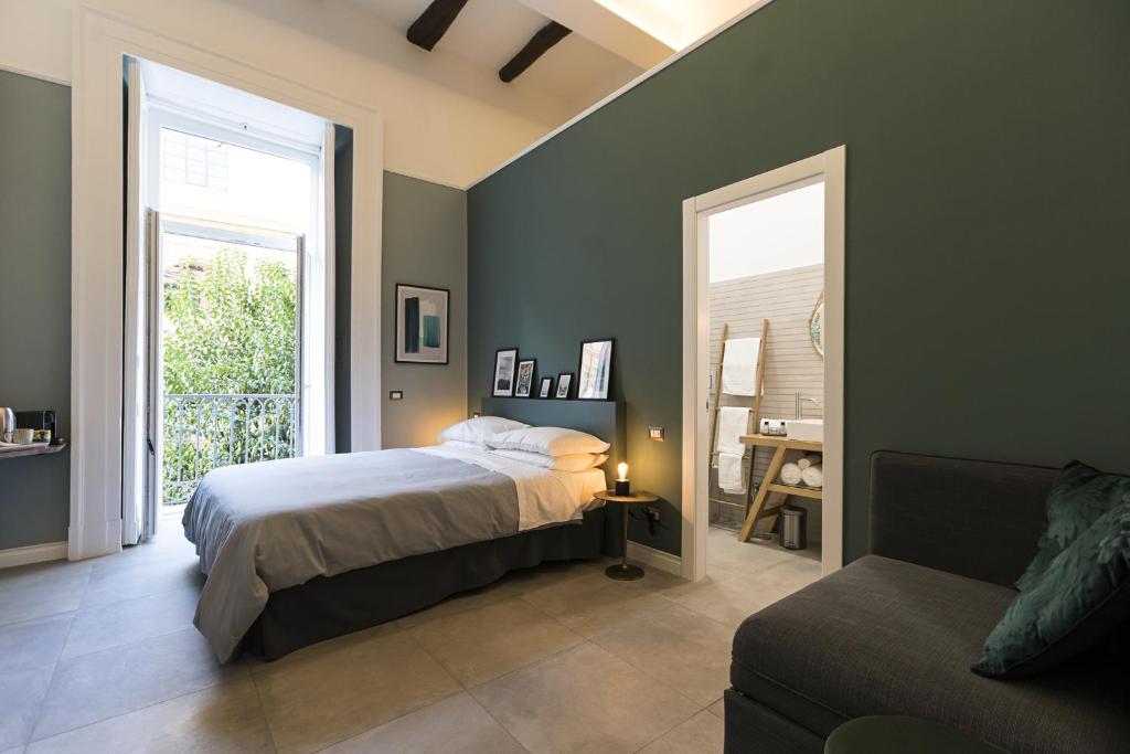 a bedroom with a bed and a window and a couch at Bellini Suite in Naples
