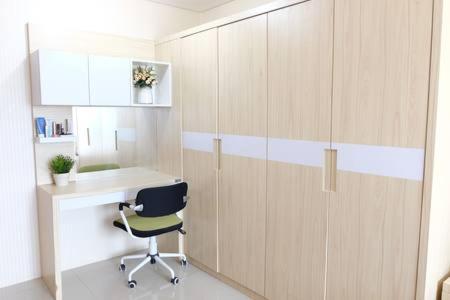 a room with a desk with a chair and a cabinet at Premium One Bedroom at Woodland Park Residence in Jakarta