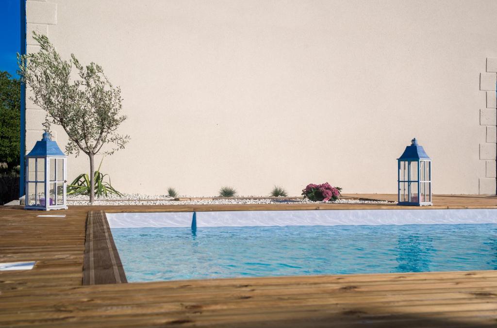 a swimming pool with two gazebos next to the water at Au pied du Lariat in Léoville