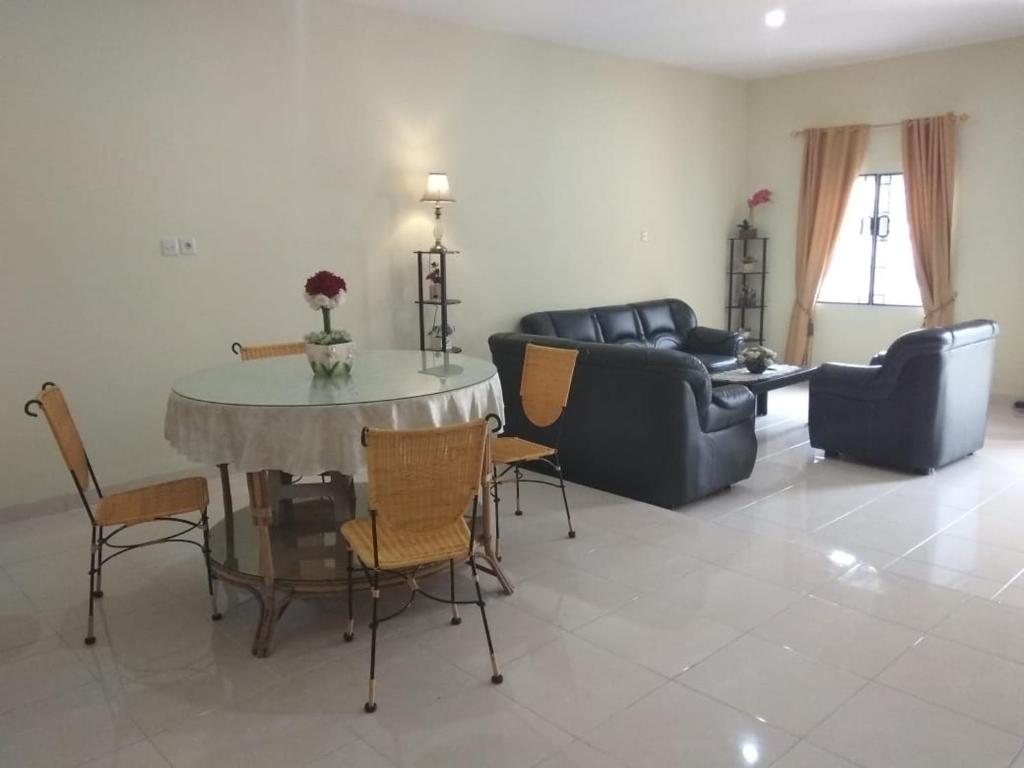 a living room with a table and chairs and a couch at Villa Brastagi Resort Jalan Mimpin Tua Blok C No. 41 in Berastagi